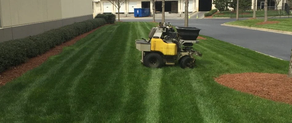 Spreader of a fire ant control treatment in Bethlehem, GA, on a lawn.