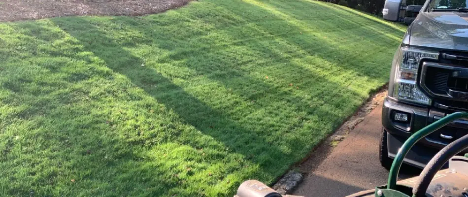 A healthy, green lawn besides a truck in Monroe, GA.